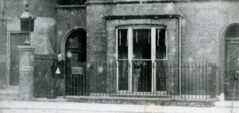 Arthur Conan Doyle in front of his doctor's office (the plaque can be seen on his left).